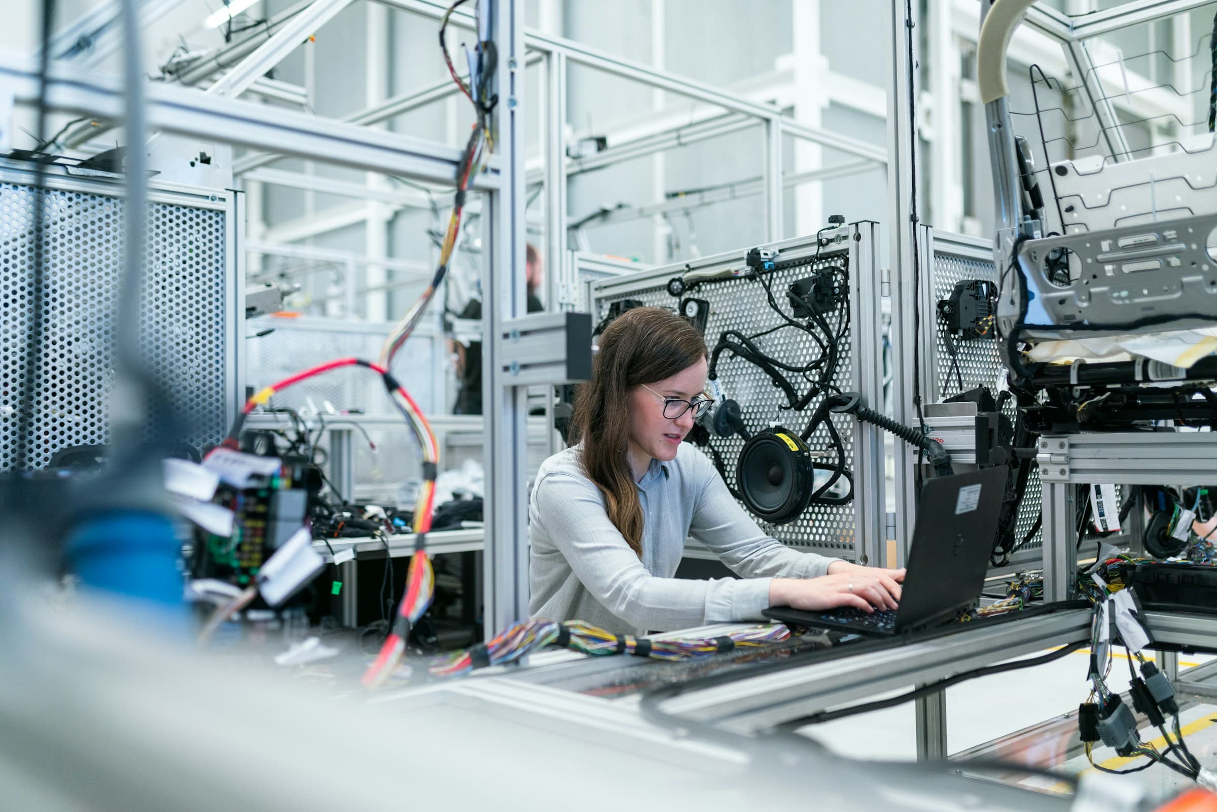 Manufacturing engineer in protective eyewear working with industrial equipment on the shop floor